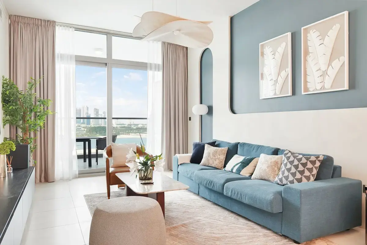 Bright living room with blue sofa and large balcony windows